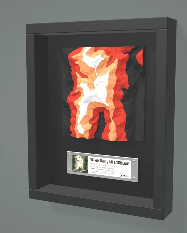Render: the Pikirakatahi / Mt Earnslaw tile in a dark shadow-box frame with a coordinate plate below it
