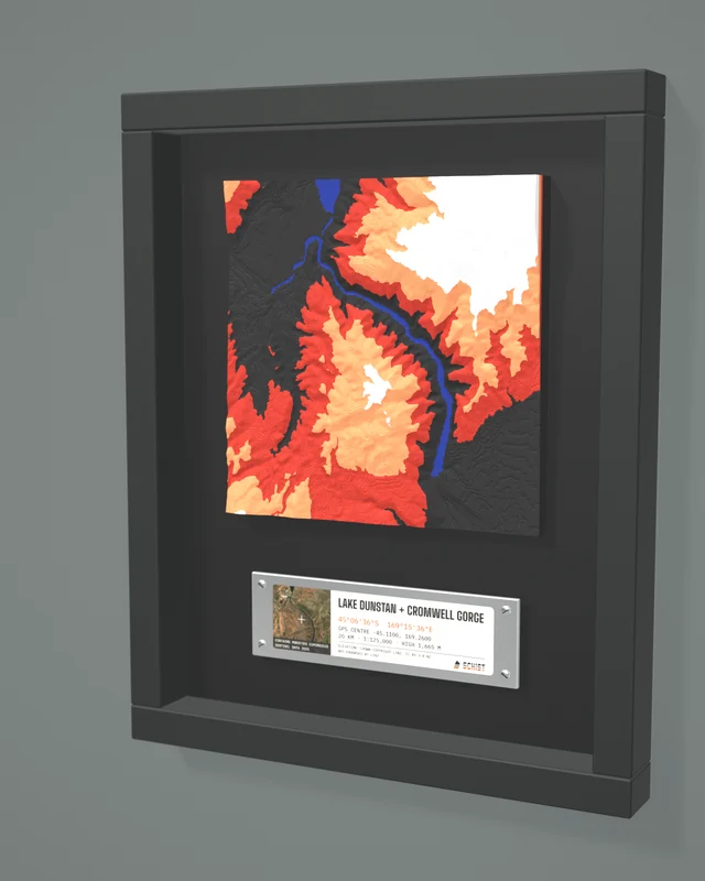 Render: the Lake Dunstan + Cromwell Gorge tile in a dark shadow-box frame with a coordinate plate below it