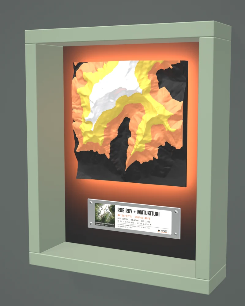 Render: the Rob Roy + Matukituki tile in Daybreak colours in a sage-green painted frame, lit from behind with an orange glow.